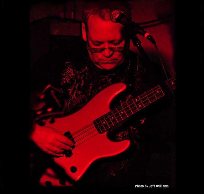 red and black color image of mike capps playing a fender pj bass